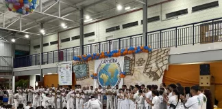 Alunos do Educandário Santa Catarina com trajes de capoeira participam da cerimônia de troca de faixa no ginásio, durante o Encontro Nacional de Capoeira.