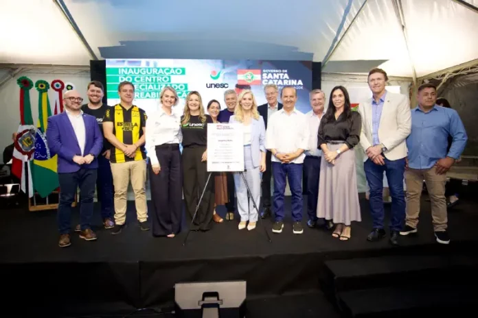 centro reabilitação A foto registra autoridades, representantes da Unesc e do Governo de Santa Catarina reunidos no palco durante a inauguração do Centro Especializado de Reabilitação, destacando a formalização e a entrega oficial do novo serviço à população.