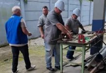 Imagem de operários em uma serralheria, usando uniformes e equipamentos de proteção individual, ilustrando as vagas de emprego disponíveis em São José.