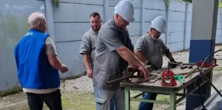 Imagem de operários em uma serralheria, usando uniformes e equipamentos de proteção individual, ilustrando as vagas de emprego disponíveis em São José.