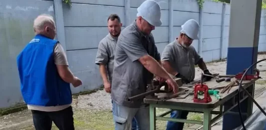 Imagem de operários em uma serralheria, usando uniformes e equipamentos de proteção individual, ilustrando as vagas de emprego disponíveis em São José.