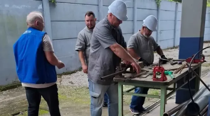 São José oferta 99 vagas de emprego e amplia cursos gratuitos de qualificação profissional Imagem de operários em uma serralheria, usando uniformes e equipamentos de proteção individual, ilustrando as vagas de emprego disponíveis em São José.