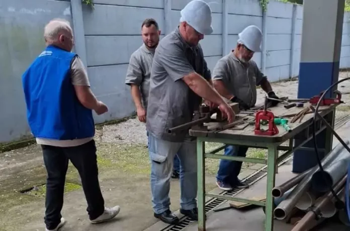 Imagem de operários em uma serralheria, usando uniformes e equipamentos de proteção individual, ilustrando as vagas de emprego disponíveis em São José.