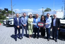 Governador lança Programa Identidade Catarina e entrega novas viaturas à Polícia Científica Foto mostra o governador de Santa Catarina, ao lado de autoridades, entregando a chave simbólica das novas viaturas à Polícia Científica durante o lançamento do Programa Identidade Catarina, simbolizando o investimento na modernização da segurança pública.