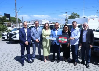 Governador lança Programa Identidade Catarina e entrega novas viaturas à Polícia Científica Foto mostra o governador de Santa Catarina, ao lado de autoridades, entregando a chave simbólica das novas viaturas à Polícia Científica durante o lançamento do Programa Identidade Catarina, simbolizando o investimento na modernização da segurança pública.