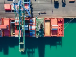 Vista aérea de terminal portuário com contêineres e navios, simbolizando o crescimento das exportações de Santa Catarina.
