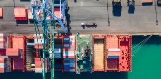 Vista aérea de terminal portuário com contêineres e navios, simbolizando o crescimento das exportações de Santa Catarina.