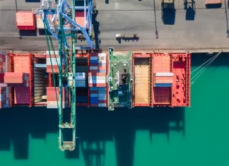 Vista aérea de terminal portuário com contêineres e navios, simbolizando o crescimento das exportações de Santa Catarina.