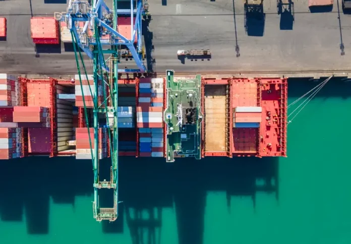 exportações Vista aérea de terminal portuário com contêineres e navios, simbolizando o crescimento das exportações de Santa Catarina.