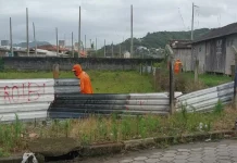 Funcionários da Prefeitura de São José desmontam cerca em terreno público para impedir ocupação irregular e proteger a área municipal.