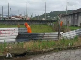 Funcionários da Prefeitura de São José desmontam cerca em terreno público para impedir ocupação irregular e proteger a área municipal.
