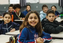 Alunos do Ensino Fundamental participando de atividades em sala de aula, com foco no aprendizado e interação entre estudantes e professor.
