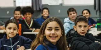 Alunos do Ensino Fundamental participando de atividades em sala de aula, com foco no aprendizado e interação entre estudantes e professor.