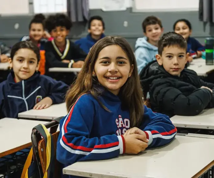 Alunos do Ensino Fundamental participando de atividades em sala de aula, com foco no aprendizado e interação entre estudantes e professor.