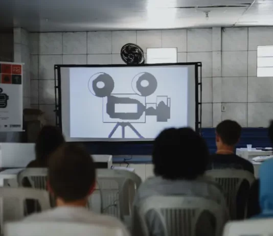 Oficina “Dazumbanho de Cinema” abre programação da Mostra Mofas na Tapera Estudantes assistindo a uma sessão de cinema da Mostra Mofas na Tapera, ilustrando as exibições gratuitas realizadas nas escolas do bairro.