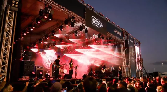 Banda se apresentando no palco da Beira-Mar de São José diante de grande público, ilustrando a realização do Mundial do Rock 2025.