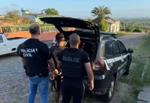 Polícia Civil desarticula grupo criminoso que manipulava sistemas de Justiça Policiais conduzem um homem preso até a viatura durante operação de combate a fraudes em sistemas digitais.