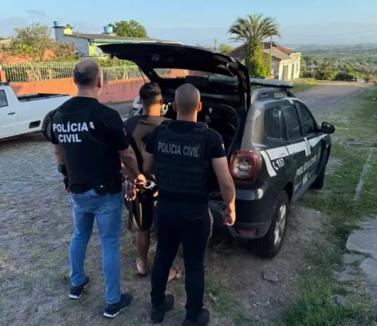 Polícia Civil desarticula grupo criminoso que manipulava sistemas de Justiça Policiais conduzem um homem preso até a viatura durante operação de combate a fraudes em sistemas digitais.