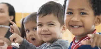 Crianças fazem lanche em creche de São José, ilustrando a oferta de vaga nas creches do município.