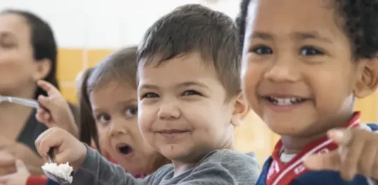 Crianças fazem lanche em creche de São José, ilustrando a oferta de vaga nas creches do município.