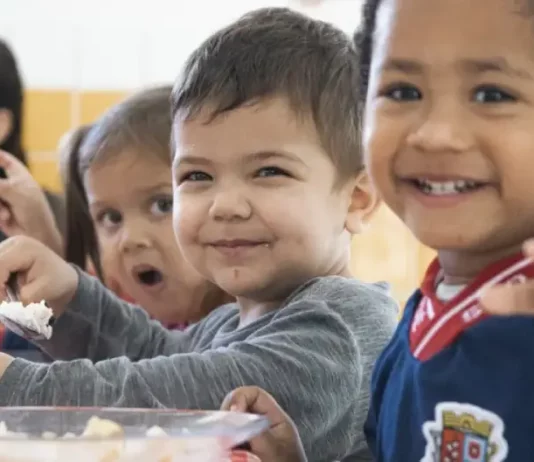Crianças fazem lanche em creche de São José, ilustrando a oferta de vaga nas creches do município.