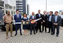 Governador e vice-governadora posam com uma chave simbólica que representa a entrega de novas viaturas para reforçar a estrutura da Polícia Civil.