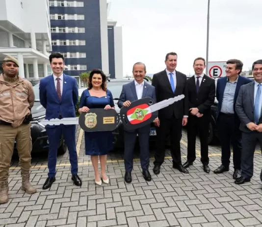 Governador e vice-governadora posam com uma chave simbólica que representa a entrega de novas viaturas para reforçar a estrutura da Polícia Civil.