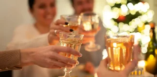 Pessoas brindando com taças em confraternização, representando celebrações de fim de ano em bares e restaurantes.