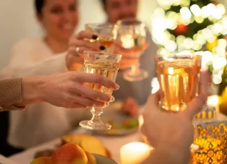 Confraternizações de fim de ano movimentam bares e restaurantes de Santa catarina Pessoas brindando com taças em confraternização, representando celebrações de fim de ano em bares e restaurantes.