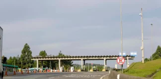 Imagem mostra uma praça de pedágio da Autopista Planalto Sul na BR-116, com cabines de cobrança, sinalização viária e pistas de acesso, ilustrando o local onde os motoristas realizam o pagamento da tarifa.