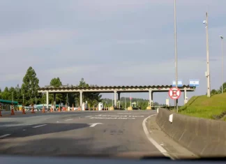 Autopista Planalto Sul terá nova tarifa de pedágio a partir de sexta (19) Imagem mostra uma praça de pedágio da Autopista Planalto Sul na BR-116, com cabines de cobrança, sinalização viária e pistas de acesso, ilustrando o local onde os motoristas realizam o pagamento da tarifa.