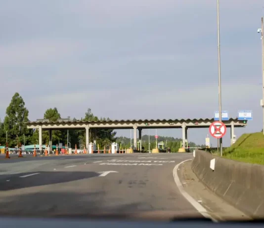 Autopista Planalto Sul terá nova tarifa de pedágio a partir de sexta (19) Imagem mostra uma praça de pedágio da Autopista Planalto Sul na BR-116, com cabines de cobrança, sinalização viária e pistas de acesso, ilustrando o local onde os motoristas realizam o pagamento da tarifa.