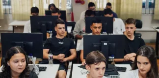 "Estudantes do ensino médio participam de aula prática em laboratório de informática, utilizando computadores lado a lado, representando a formação técnica oferecida pelo programa CaTec+ para preparar jovens para o mercado de trabalho."