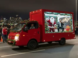 Caminhão vitrine do evento Natal de Todos circula pelas ruas de São José exibindo Papai Noel e um violinista em apresentação ao vivo, com a finalidade de levar música e clima natalino aos bairros.