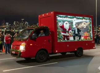 Caminhão vitrine do evento Natal de Todos circula pelas ruas de São José exibindo Papai Noel e um violinista em apresentação ao vivo, com a finalidade de levar música e clima natalino aos bairros.