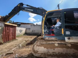 Governador Jorginho Mello ao volante de uma escavadeira durante o ato simbólico de demolição de estruturas do Complexo Penitenciário da Agronômica, em Florianópolis.