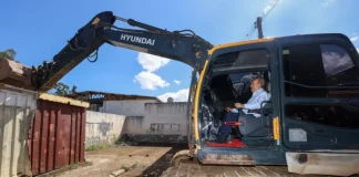 Governador Jorginho Mello ao volante de uma escavadeira durante o ato simbólico de demolição de estruturas do Complexo Penitenciário da Agronômica, em Florianópolis.