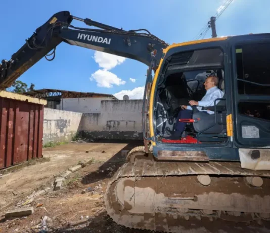Governador Jorginho Mello ao volante de uma escavadeira durante o ato simbólico de demolição de estruturas do Complexo Penitenciário da Agronômica, em Florianópolis.