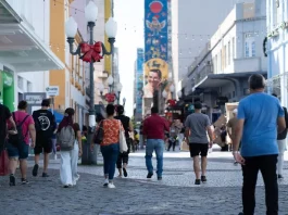 Santa Catarina tem a melhor distribuição de renda do país, aponta IBGE Pessoas caminham pelo centro de Florianópolis em dia ensolarado, ilustrando a movimentação urbana e o cotidiano da população no contexto da matéria sobre distribuição de renda em Santa Catarina.
