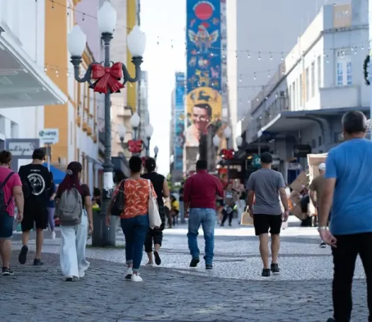 Santa Catarina tem a melhor distribuição de renda do país, aponta IBGE Pessoas caminham pelo centro de Florianópolis em dia ensolarado, ilustrando a movimentação urbana e o cotidiano da população no contexto da matéria sobre distribuição de renda em Santa Catarina.