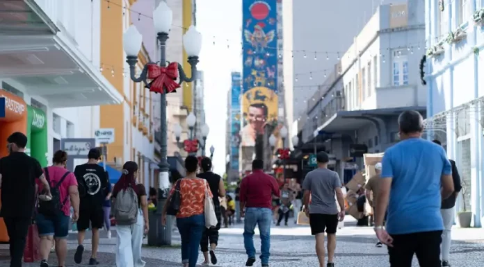 Santa Catarina tem a melhor distribuição de renda do país, aponta IBGE Pessoas caminham pelo centro de Florianópolis em dia ensolarado, ilustrando a movimentação urbana e o cotidiano da população no contexto da matéria sobre distribuição de renda em Santa Catarina.