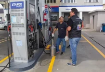 Fiscais do Procon realizam teste de qualidade em bomba de combustível com equipamento de medição ao lado da área de etanol comum durante operação de inspeção em postos de combustíveis da cidade.