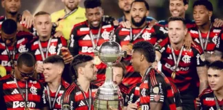 Jogadores do Flamengo erguem a taça comemorando o tetra da Libertadores, celebrando a conquista histórica do clube.
