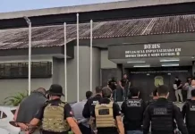 Polícia Civil prende suspeitos de homicídio no Campeche Policiais escoltam suspeitos de homicídio no bairro Campeche durante operação policial
