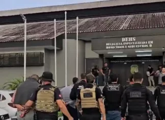 Polícia Civil prende suspeitos de homicídio no Campeche Policiais escoltam suspeitos de homicídio no bairro Campeche durante operação policial