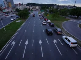 Carros circulando em área urbana, ilustrando o tráfego de veículos sujeitos ao pagamento do IPVA em Santa Catarina.