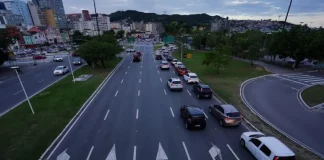 Carros circulando em área urbana, ilustrando o tráfego de veículos sujeitos ao pagamento do IPVA em Santa Catarina.