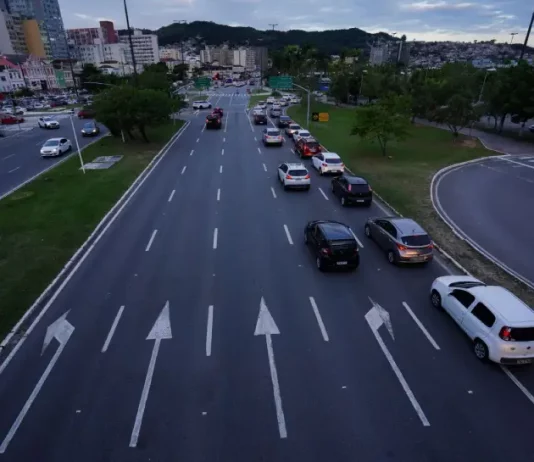 Carros circulando em área urbana, ilustrando o tráfego de veículos sujeitos ao pagamento do IPVA em Santa Catarina.