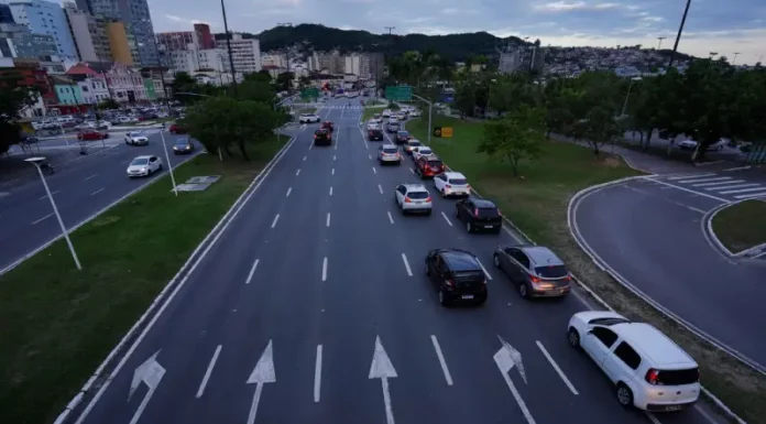 Carros circulando em área urbana, ilustrando o tráfego de veículos sujeitos ao pagamento do IPVA em Santa Catarina.