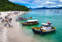 Florianópolis define regras para transporte e visitação à Ilha do Campeche A imagem mostra embarcações realizando o desembarque de visitantes na Ilha do Campeche, ilustrando o transporte turístico que atende a operação de acesso e visitação ao local.